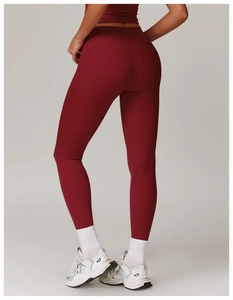 Close-up of high-waisted burgundy yoga leggings with peach lift effect and quick-dry fabric