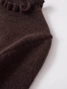 Detailed close-up of dark brown knit sweater featuring ruffled collar and soft texture