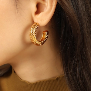 Modern gold-tone C-shape hammered texture titanium steel hoop earrings on model