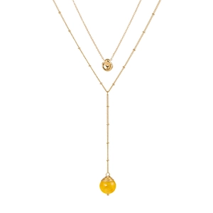 Détail d'un collier doré double rang avec pierre jaune et pendentifs irréguliers