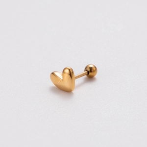 Macro shot of polished gold heart-shaped stainless steel barbell earring for cartilage