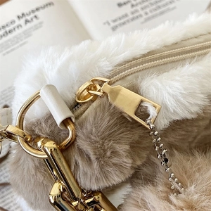 Furry cow print tote bag featuring cream and camel plush fabric with gold metal zipper