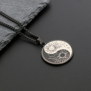 Détail du collier Yin Yang avec motifs célestes de soleil et lune sur surface en pierre