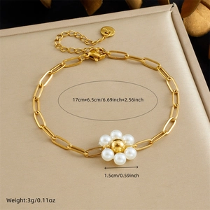 Dettaglio del bracciale in acciaio dorato con ciondolo a fiore di perla su portagioie
