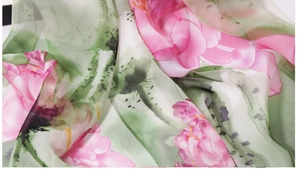 Close-up of silk scarf featuring lotus floral print and elegant ink painting textures