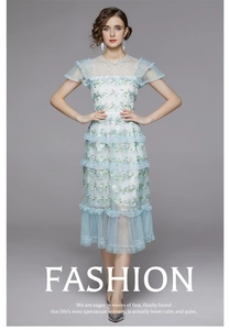 Détails de la robe à volants en dentelle bleu clair avec broderies et col en tulle