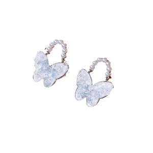 Blue crystal butterfly earrings with pearl accents and silver needles on white background
