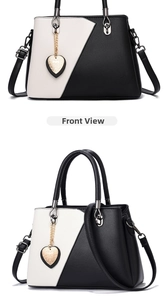 Front and side view of chic black and white color-block handbag with heart pendant