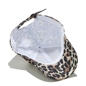 Interior detail of leopard print baseball cap showing 100% polyester label and adjustable strap