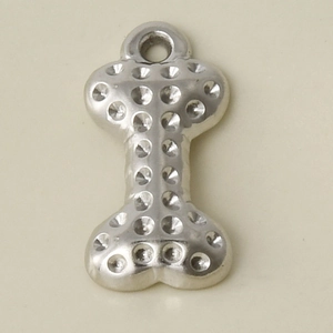 Macro detail of dog bone pendant in 304 stainless steel with dotted metal texture