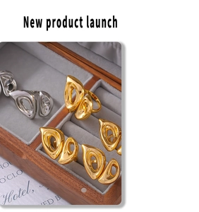 Detail of gold and silver hollow leaf rings displayed on a gray velvet jewelry tray