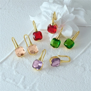 Detailed shot of cushion-cut colorful gemstones on gold S925 silver ear hooks