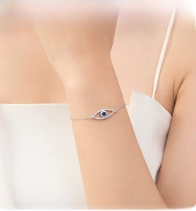 Detail of S925 silver Evil Eye bracelet with blue crystal and pavé diamonds on wrist