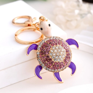 Detailed macro view of purple turtle keychain with rhinestones and golden clasp hardware