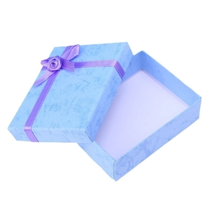 Light blue jewelry gift box with purple ribbon and floral decoration on white background
