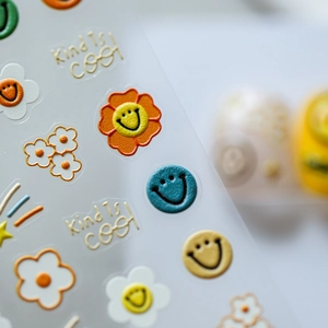 3D embossed nail stickers featuring colorful flowers and smiles with Kind is cool slogan