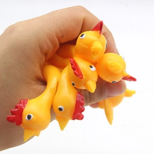 Yellow rubber slingshot chickens for stress relief being held in a person's hand