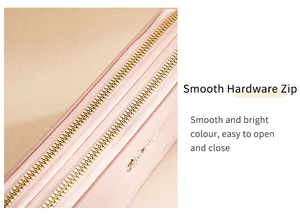Close-up of smooth dual golden hardware zippers on a pink faux leather long wallet