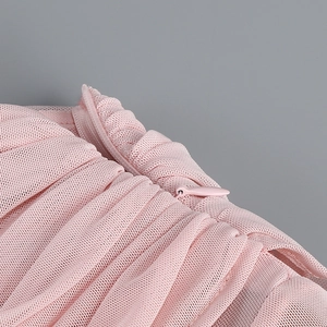 Gros plan du tissu en maille rose et détails de la fermeture éclair sur la robe