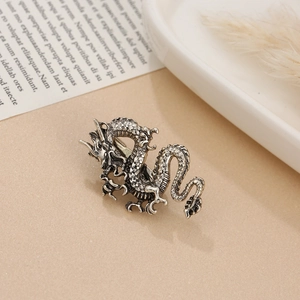 Detailed close-up of a vintage silver coiled dragon ring with intricate scale textures
