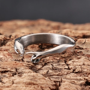 Artistic 'Hand of God' open ring in silver finish displayed on natural wood bark