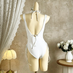 Detailed back view of white backless swimsuit with elegant drawstring ties and straps
