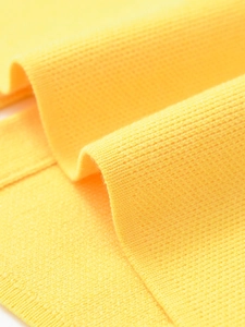 Macro shot of bright yellow ribbed knit fabric texture with fine vertical stitching detail