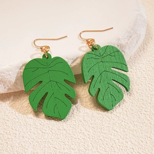 Detailed close-up of green leaf earrings showing wood texture and golden hooks