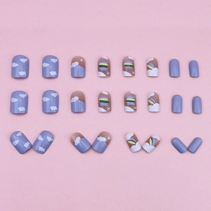 Dreamy purple press-on nail kit with rainbow and cloud designs on a pink background