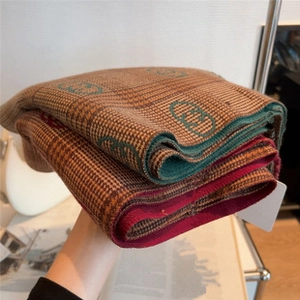 Detail of thick winter scarf with classic double G patterns and plush knitted texture