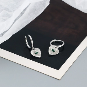 Detailed close-up of 925 silver heart hoop earrings with a green marquise stone inlay