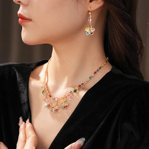 Macro view of colorful zircon flower necklace and earrings set worn by a model