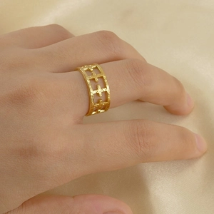 Detailed view of adjustable gold ring featuring hollow cross pattern and hammered metal texture