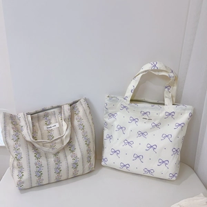 Detailed view of floral canvas tote bags with Simple Wish tags and zipper closure