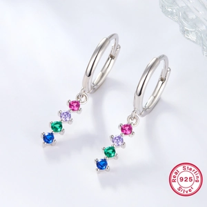 Macro shot of 925 sterling silver hoop earrings with four colored gemstone pendants