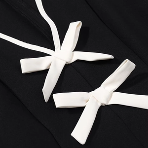 Gros plan de nœuds décoratifs blancs sur tissu noir montrant la texture du textile