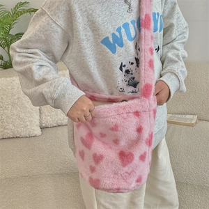 Detailed view of pink plush heart-patterned crossbody bag with wide shoulder strap