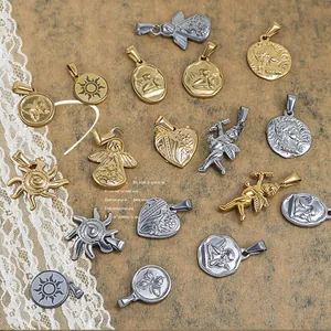 Detailed close-up of gold and silver sun, heart, and angel charms on textured stone