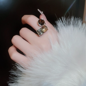 Detail of square and round amber zircon geometric ring on model with warm fur background