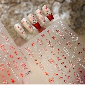Macro detail of 3D embossed red bamboo nail stickers with golden butterfly accents