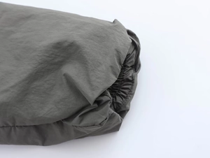 Detail of windproof elastic cuff on olive green quilted jacket with crinkled texture fabric