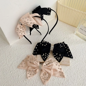 Detalle de elegantes diademas con lazo de diamantes negros y rosas en fondo texturizado