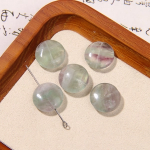 Macro shot of polished round natural fluorite beads with purple and green textures