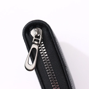 Macro shot of high-quality black leather texture with durable silver metal zipper detail