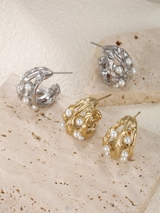 Detailed shot of hollow lava-style pearl earrings in gold and silver finish
