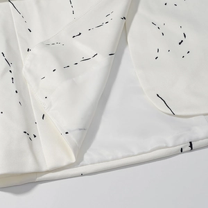 Detailed close-up showing white graffiti blazer hem with silky polyester inner lining