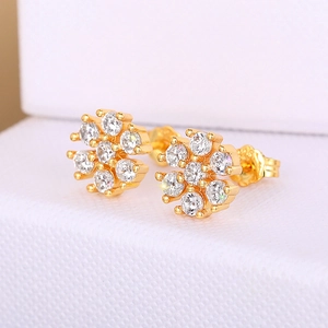 Macro shot of elegant gold flower stud earrings with sparkling round clear gemstones