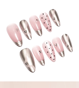 Detailed view of pink cat-eye press-on nails with silver metallic accents and rhinestones