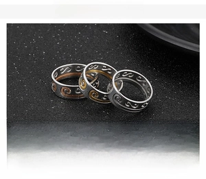 Macro shot of three stacked punk stainless steel rings with embossed cloud patterns