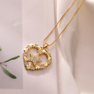 Detailed view of a gold heart pendant with zircon star on soft silk background